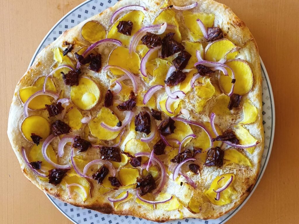 Flammkuchen mit Kartoffeln, Zwiebeln und getrockneten Tomaten